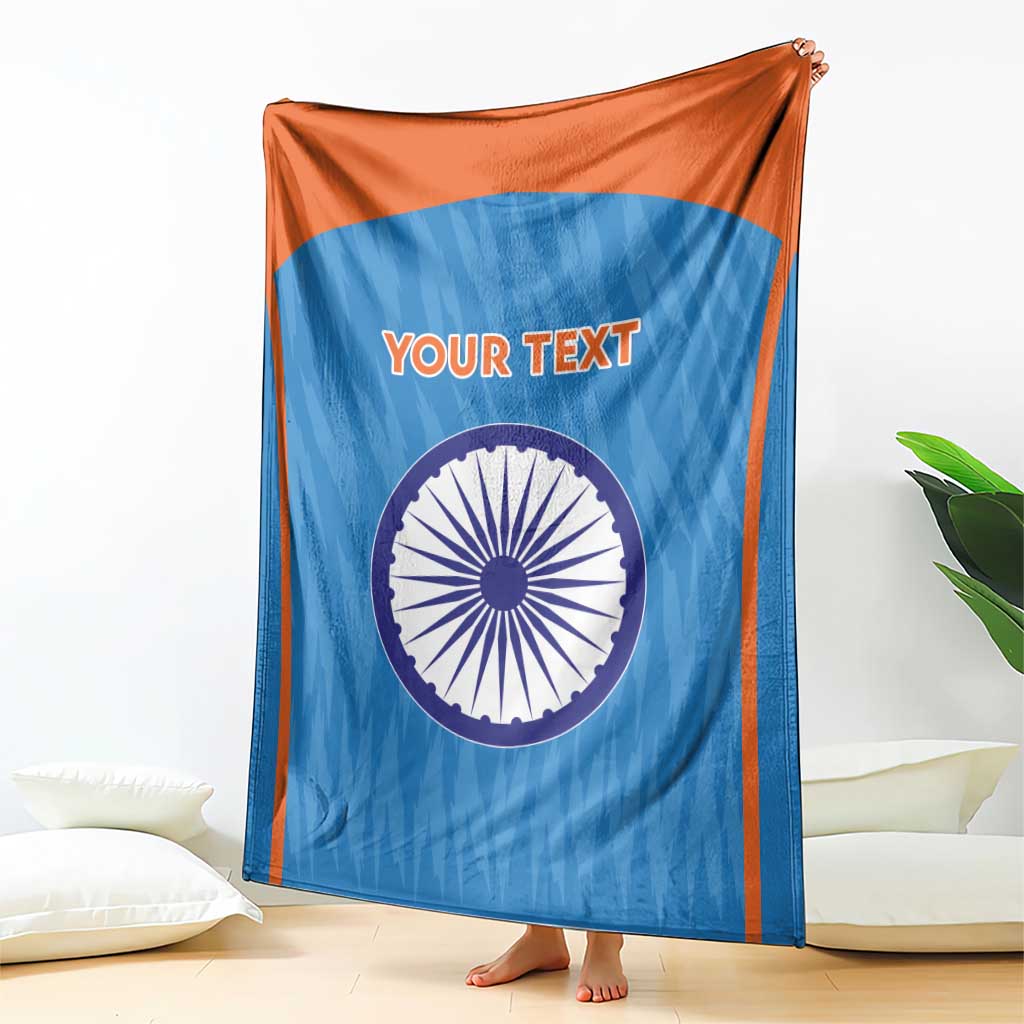 Blue cricket blanket with orange border, Indian emblem circle and 'YOUR TEXT', draped.