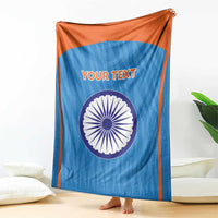 Blue cricket blanket with orange border, Indian emblem circle and 'YOUR TEXT', draped.