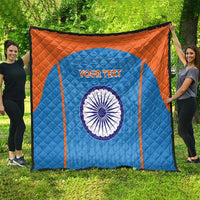 Orange-and-blue cricket quilt draped outdoors, India emblem and 'YOUR TEXT' on diamond quilting.