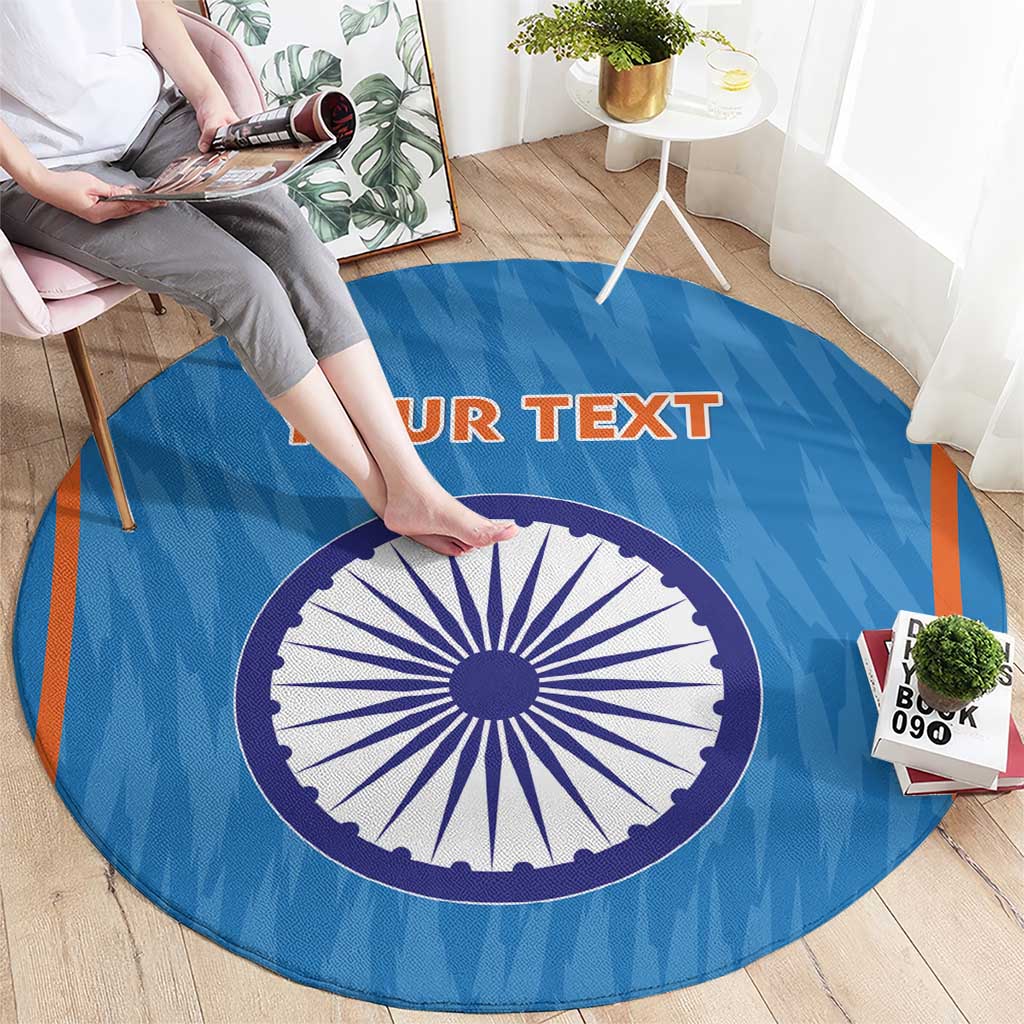Blue round cricket rug with central India-style wheel graphic and orange accents