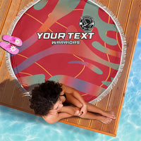 Round beach blanket with white fringe, red and green abstract pattern and Warriors logo