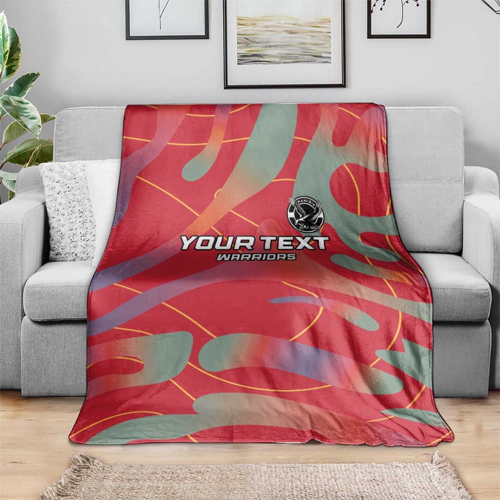 Red and teal football blanket on sofa with YOUR TEXT WARRIORS print and emblem
