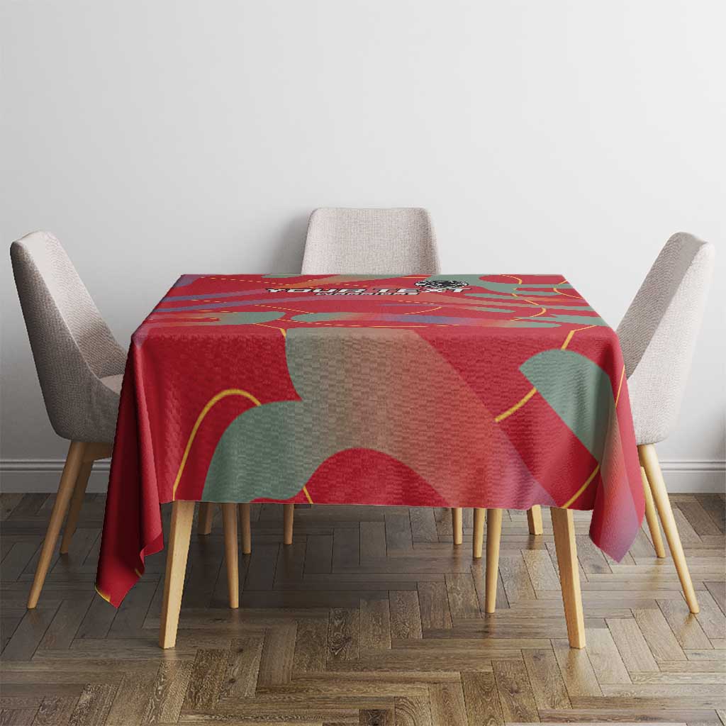 Red patterned football tablecloth on square table with abstract green and yellow shapes