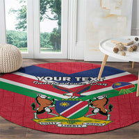 Red round rug with centered Namibia flag coat of arms design