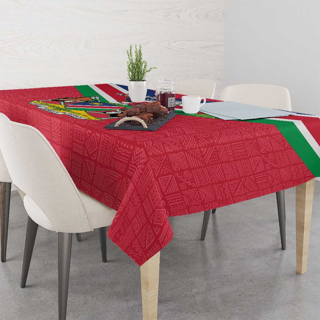 Red Namibia flag-themed tablecloth draped over dining table with coat of arms