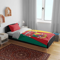 Cameroon bedding set on bed: lion crest duvet with red, green, and yellow panels