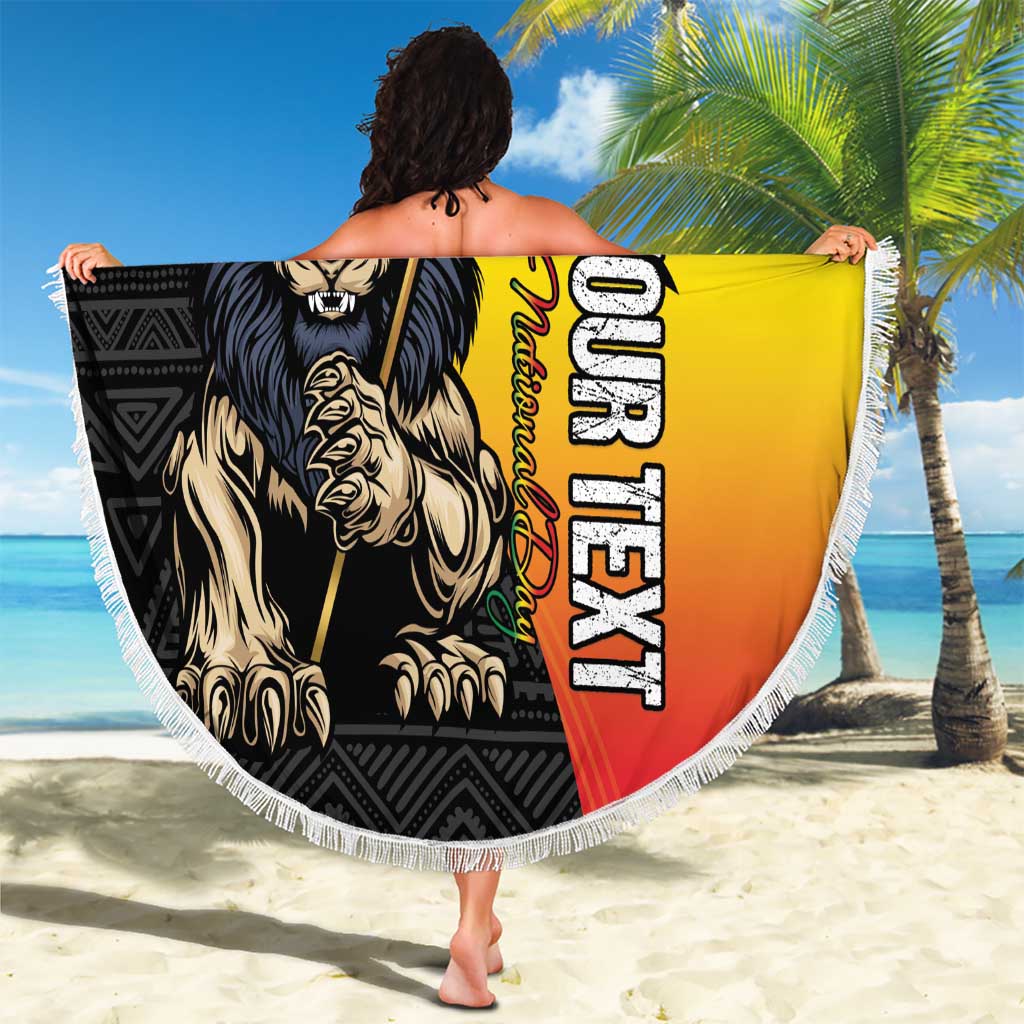 Round beach blanket held up, showing Lion of Judah and Ethiopian colors, white fringe