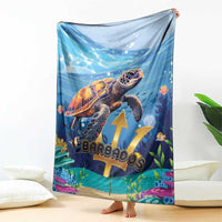 Blue sea turtle blanket with ocean artwork and gold emblem, draped over couch