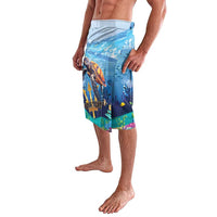 Blue ocean-themed shorts with sea turtle artwork and tropical plants, side view