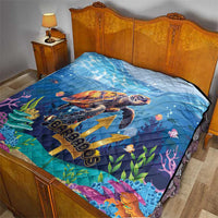 Blue quilt on bed with sea turtle print, diamond quilting, colorful reef and "Barbados"