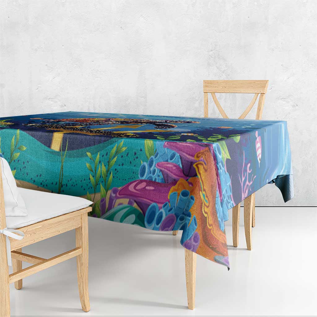 Blue ocean sea turtle tablecloth draped over table, multicolor coral and marine print