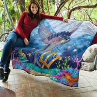 Ocean-style blue quilt with flying fish artwork, gold emblem, and bright underwater scenery