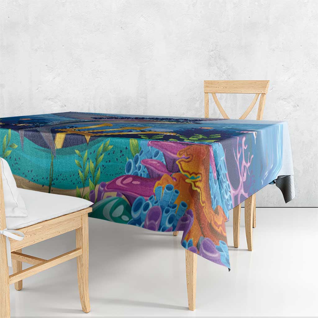 Square ocean tablecloth draped on a table with colorful underwater fish and coral patterns