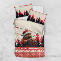 Christmas bedding set shown laid flat: quilt with pine marten violin scene and matching pillows