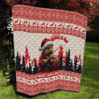 Red Christmas quilt with pine marten playing violin and pine trees, bordered with 'Merry Christmas'.