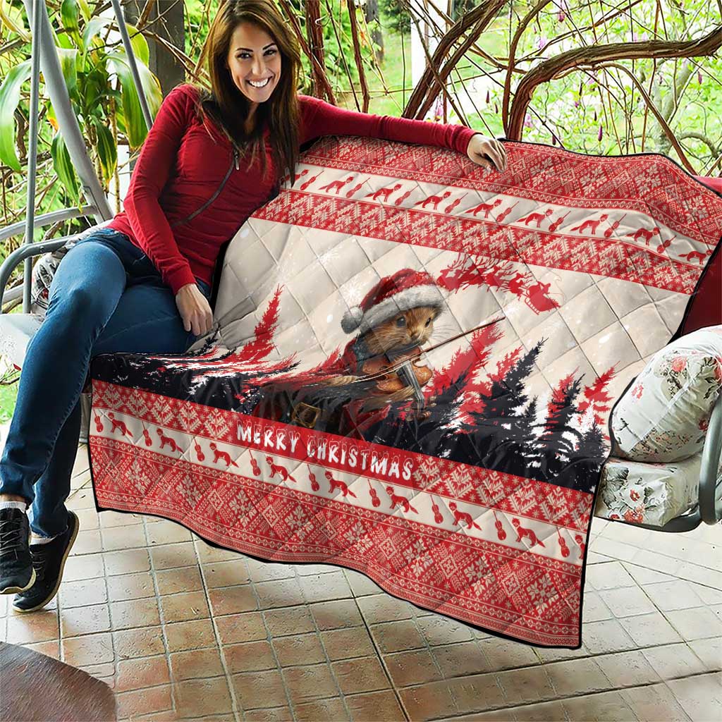 Red Christmas quilt draped on outdoor seating, featuring pine marten playing violin and 'Merry Christmas'.