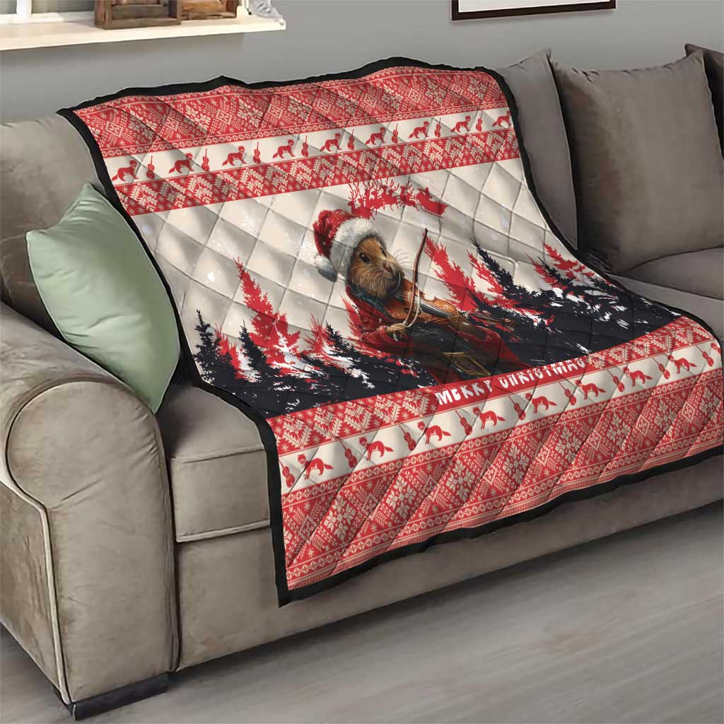 Red Christmas quilt spread on a gray sofa, with pine marten playing violin and 'Merry Christmas'.