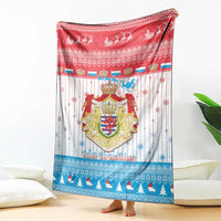 Christmas blanket with red top section and Luxembourg crest, corner draped on floor
