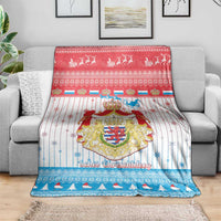 Christmas blanket with coat of arms and festive border, folded over gray sofa back