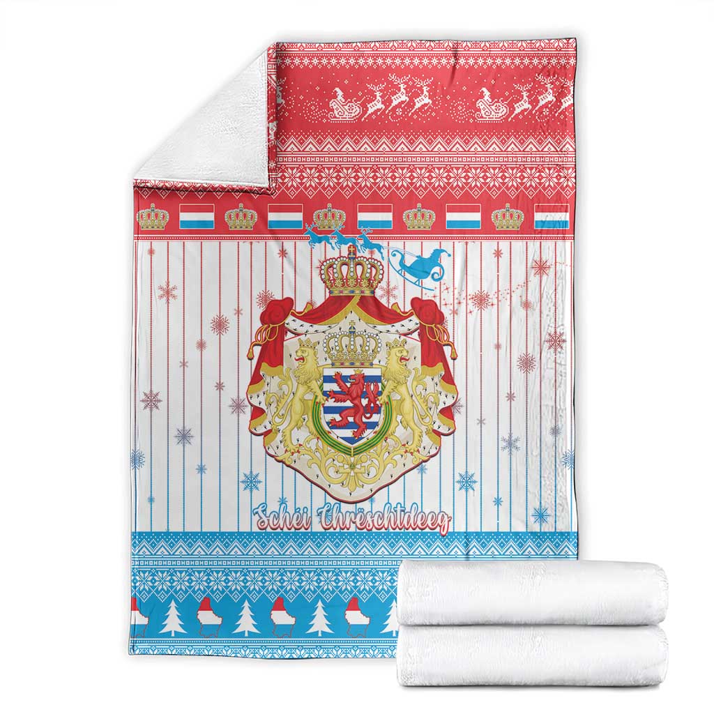 Christmas blanket with Luxembourg crest graphic, with folded white towels underneath