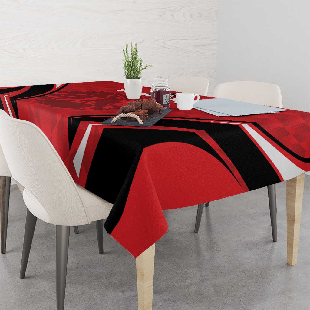 Red, black, and white football tablecloth covering dining table with small centerpiece