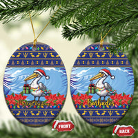 Ceramic Christmas ornament set, oval blue pelican with poinsettias; “Merry Christmas” and “Barbados”