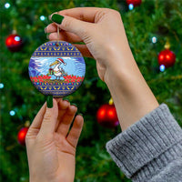 Ceramic Christmas ornament, round blue pelican with poinsettias; held on gold hanging cord