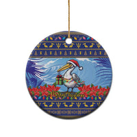 Ceramic Christmas ornament, round blue pelican and poinsettias; hanging loop at top