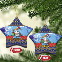 Ceramic Christmas ornament, star-shaped blue pelican with poinsettias; “Merry Christmas”