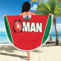 Red circular beach blanket with green stripe, printed Oman cricket logo, and fringe trim