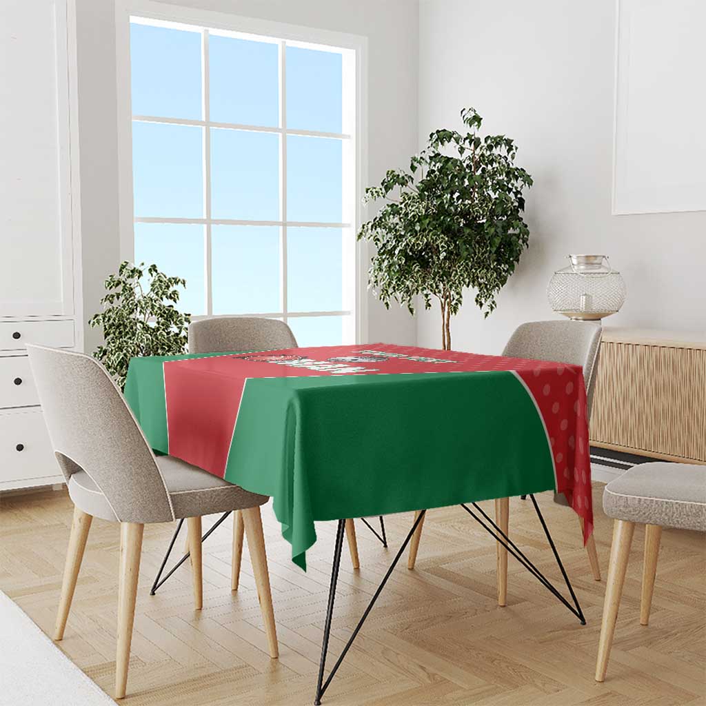 Red and green cricket tablecloth with bold Oman graphic covering a dining table