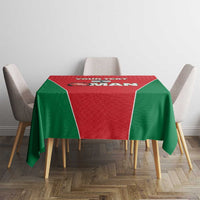 Red and green cricket tablecloth on a dining table with chair backs visible