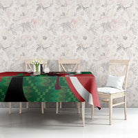 Red, green and white athletics tablecloth on dining table with floral wall backdrop