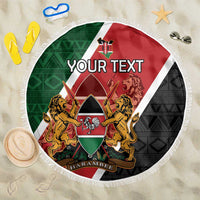 Round personalized Kenya beach blanket, red-green-black coat of arms center, fringe border