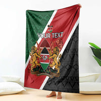 Personalised Kenya blanket draped over couch; red, green, white and black diagonal stripes, coat of arms