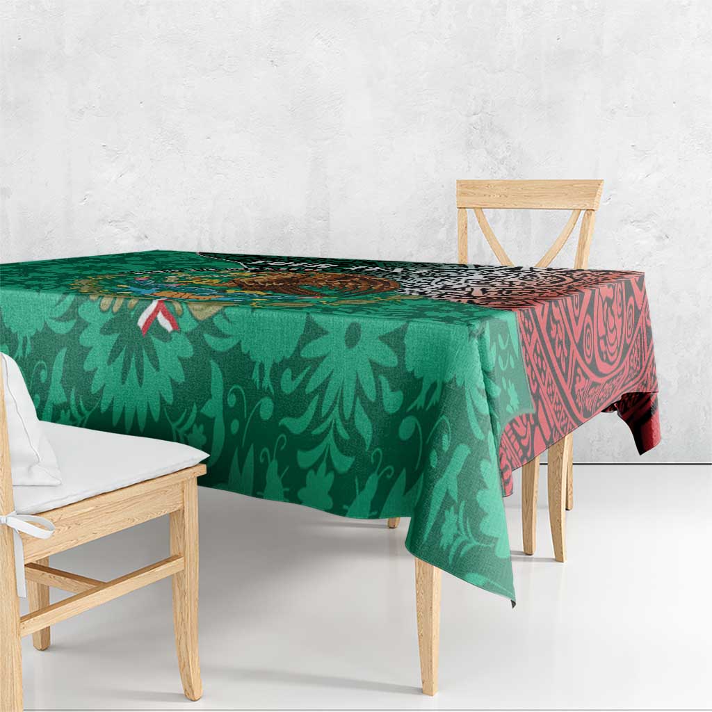 Green tablecloth with leaf pattern and red Aztec-style border, draped over dining table