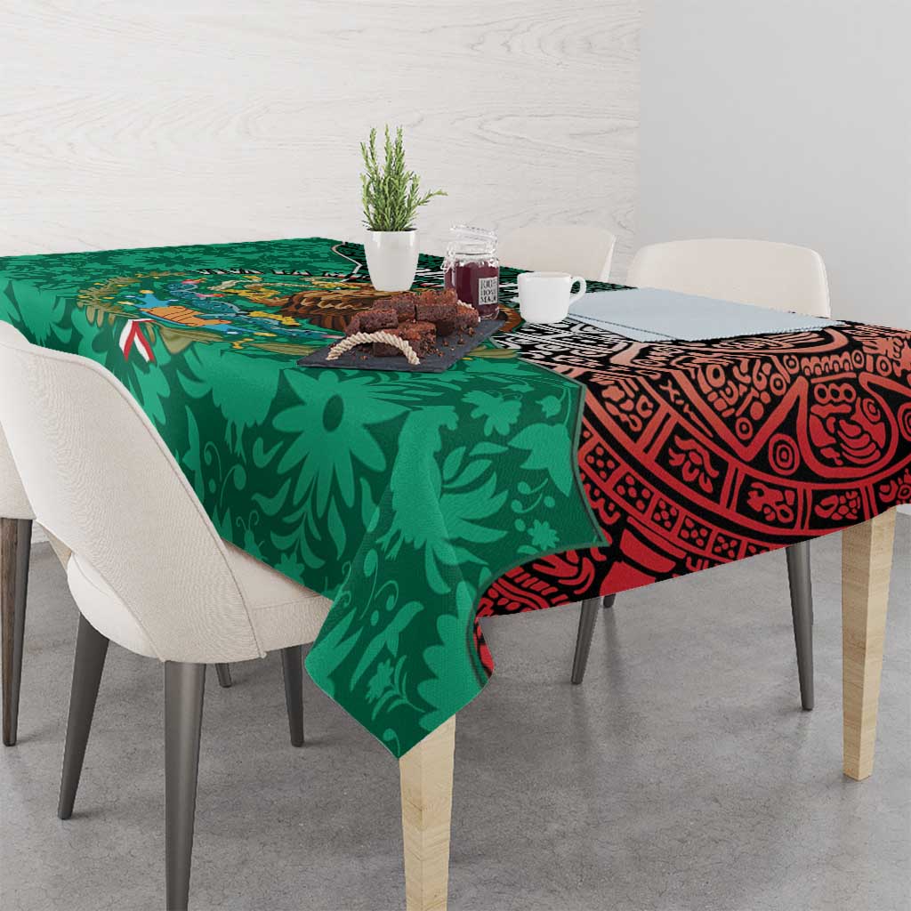 Green tablecloth with bold geometric Aztec motif and red trim across dining table