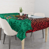 Green tablecloth with bold geometric Aztec motif and red trim across dining table