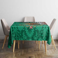 Green printed tablecloth with leaf shapes and small red accents, laid on dining table