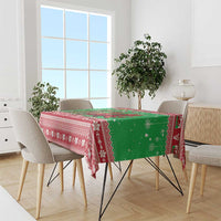 Green holiday tablecloth with red border and dragon motif across the tabletop