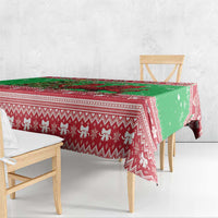 Green holiday tablecloth with red zigzag and reindeer motifs, draped over chairs