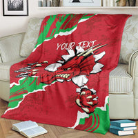 Personalised Wales blanket on sofa with red dragon illustration, green-white flag border, Your Text