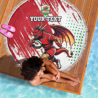 Round red beach blanket with white fringe, Wales dragon mascot and green dot pattern