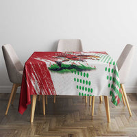 Red and white tablecloth for dining table with Welsh dragon print and green dotted field.