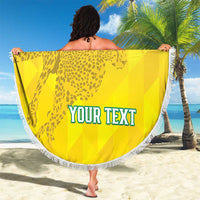 Yellow round beach blanket with leopard graphic and flag stripes, white fringe, 'YOUR TEXT', held up.
