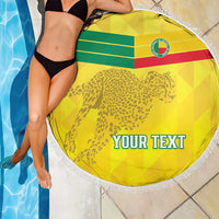 Yellow round beach blanket with leopard and flag stripes, white fringe edge, 'YOUR TEXT', draped.