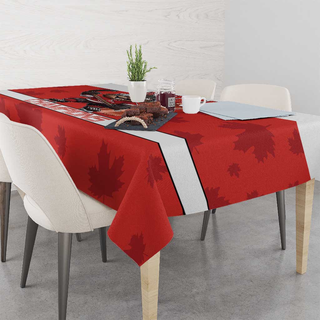Red tablecloth with maple leaf pattern and dark center stripe, draped over a dining table.