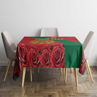 Square red tablecloth with green side panel and bold rose motif print.