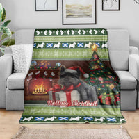 Green Christmas throw blanket featuring Scottish terrier, fireplace lights, tree and gift graphics.