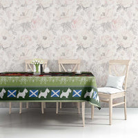 Holiday tablecloth in green with terrier silhouettes and blue cross motifs on dining table